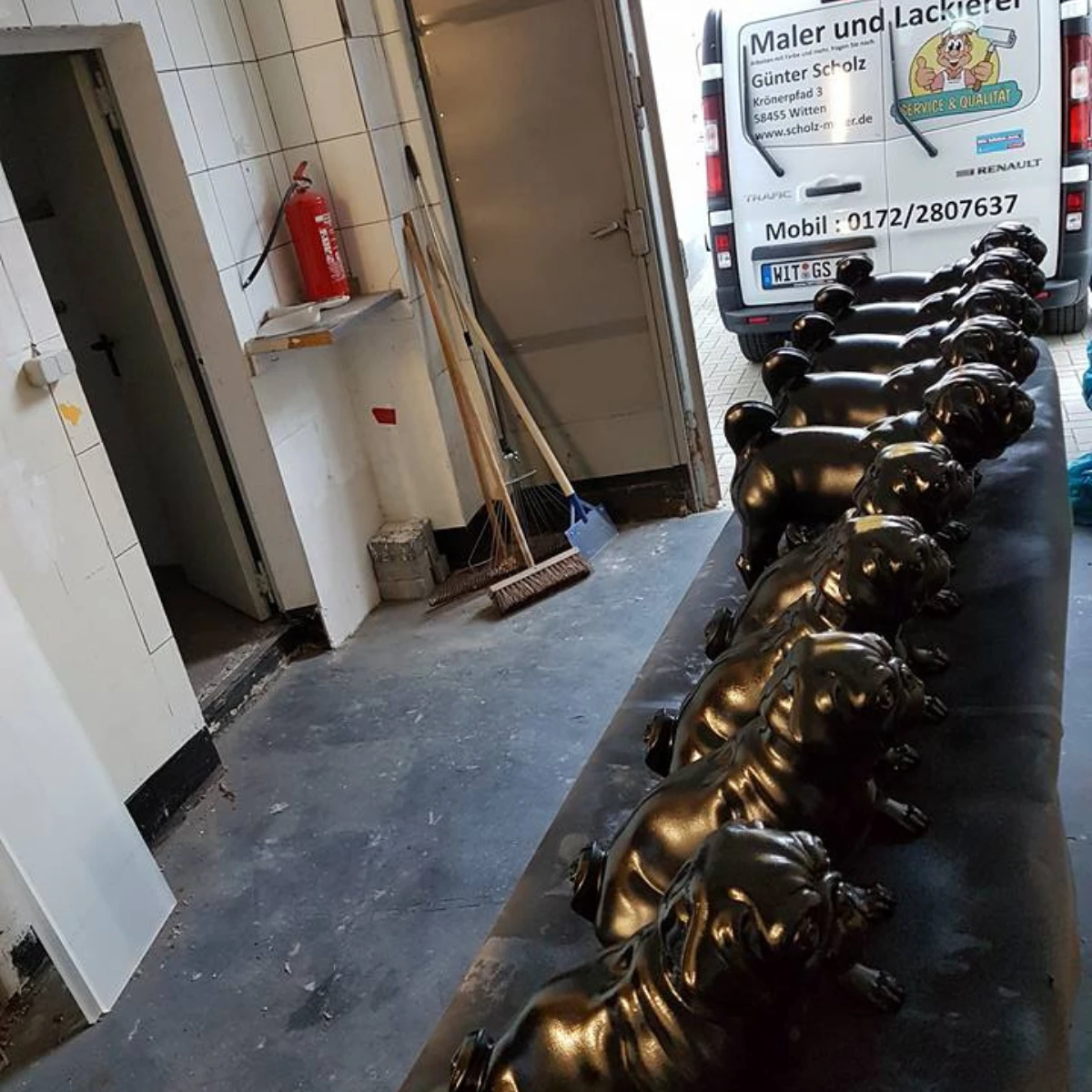 MOPS BALTZ Mehrere schwarz glänzend lackierte Figuren liegen zum Trocknen.