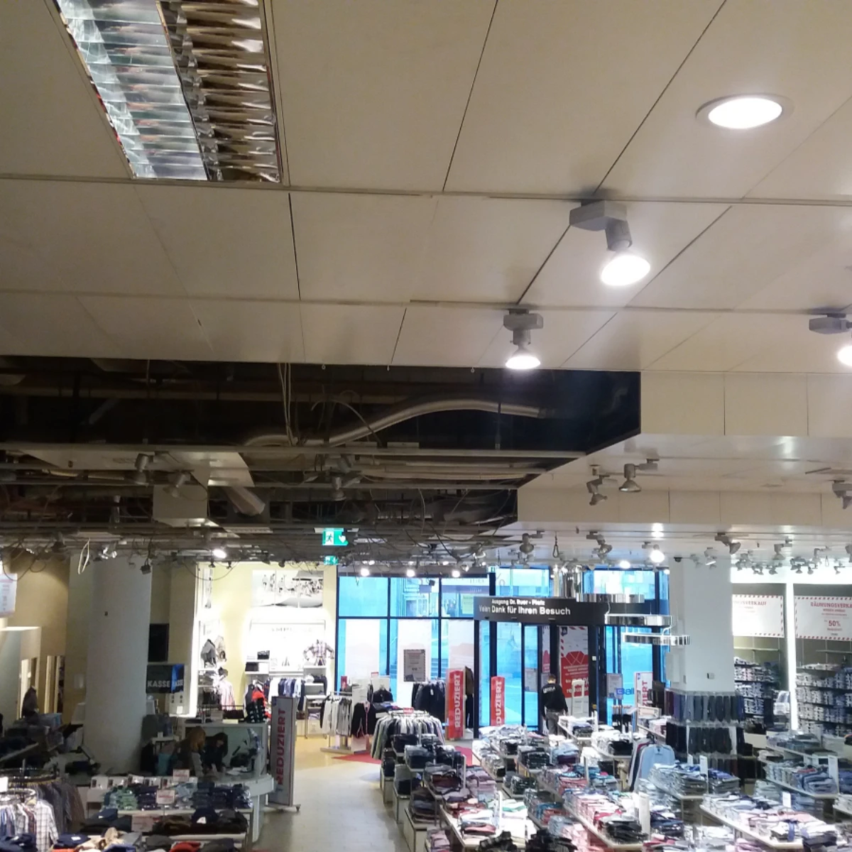 Innenraum Baltz vorher Innenraum eines Modegeschäfts während Renovierungsarbeiten, mit offener Decke und Verkaufsfläche im Hintergrund.