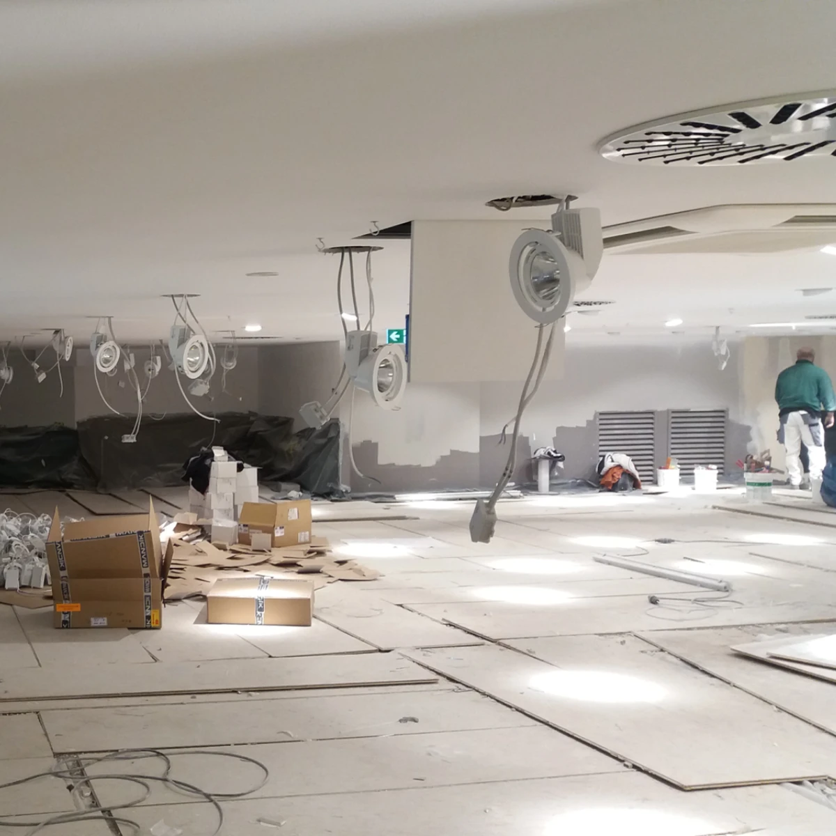 Deckeninstallationen Maler Scholz Große Baustelle im Innenbereich mit Kartons, Werkzeugen und vorbereiteten Deckeninstallationen.