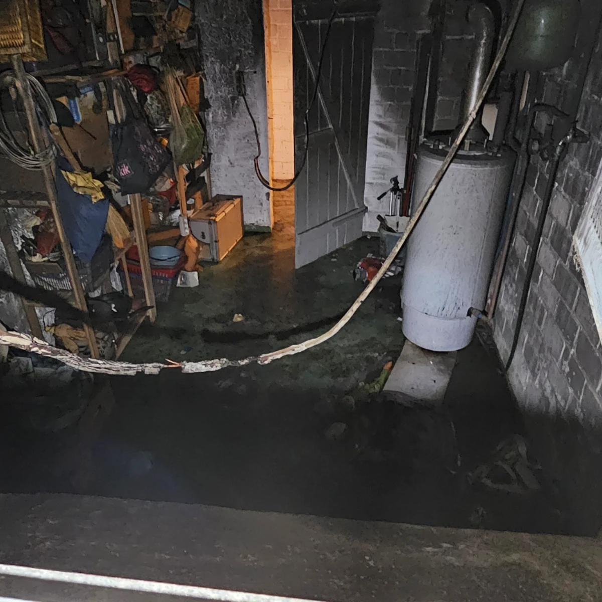 Verbrannter Keller Verbrannter und überfluteter Kellerraum nach einem Brand, mit beschädigter Heizungstechnik und Werkstattgegenständen.