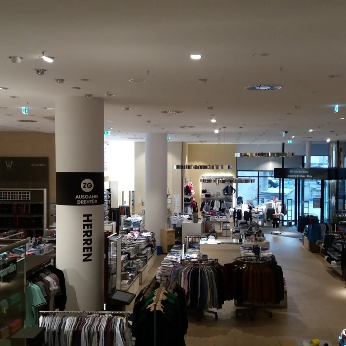 Baltz nach den Malerarbeiten innen Ansicht eines modernen Ladenlokals mit Kleidung, Regalen und Deckenbeleuchtung - nach den Malerarbeiten